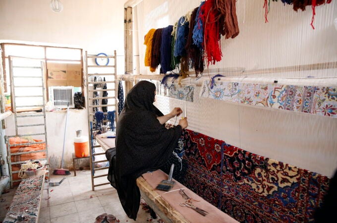 Iranian women weave handmade rugs in Nushabad