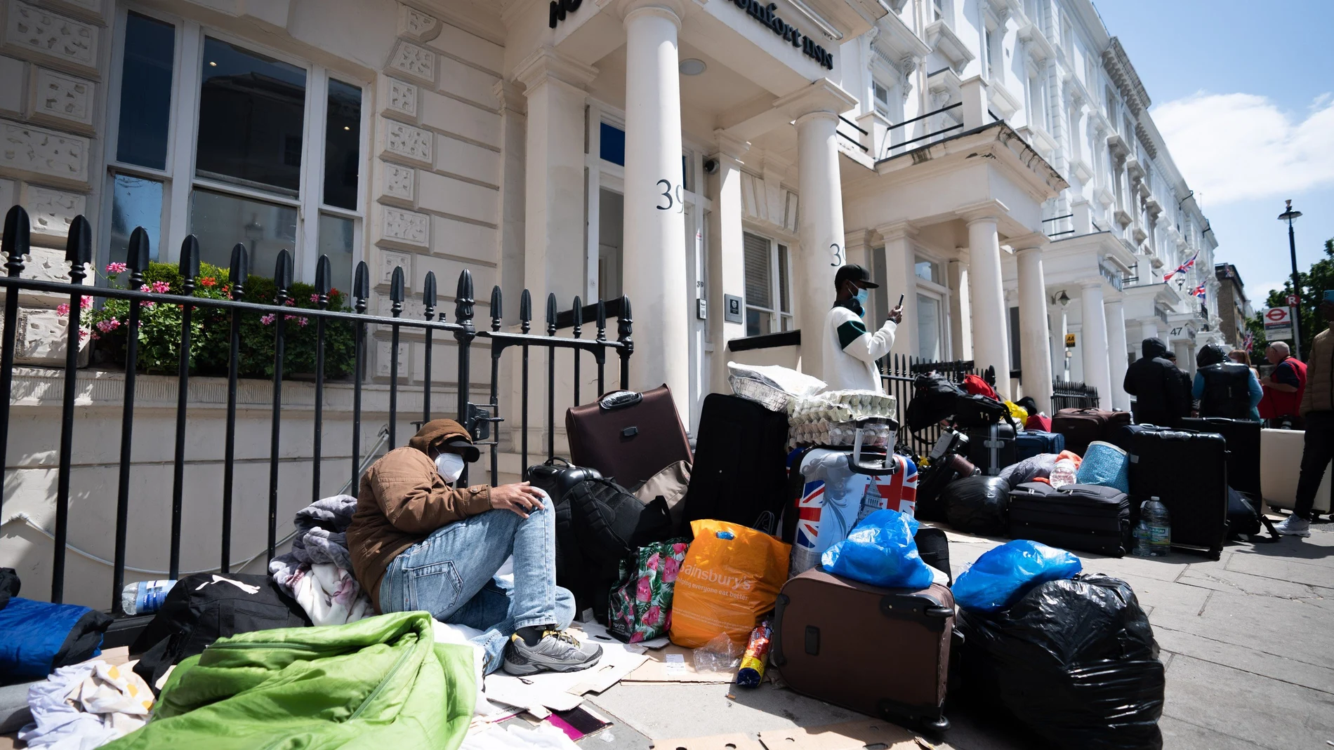 Refugiados aguardan en el exterior de un hotel en Londres