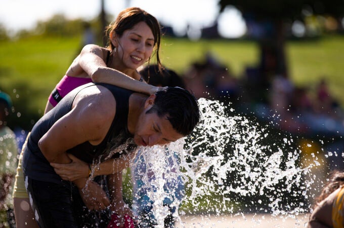 Gente refrescándose en chorros de agua por las altas temperaturas de la ola de calor en Madrid. © Jesús G. Fer
