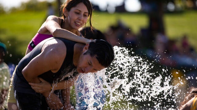 Gente refrescándose en chorros de agua por las altas temperaturas de la ola de calor en Madrid.
© Jesús G. Fer