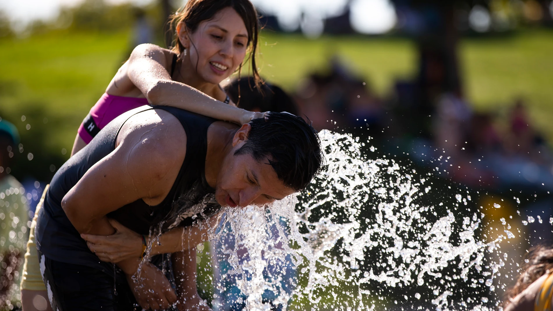Gente refrescándose en chorros de agua por las altas temperaturas de la ola de calor en Madrid. © Jesús G. Feria.