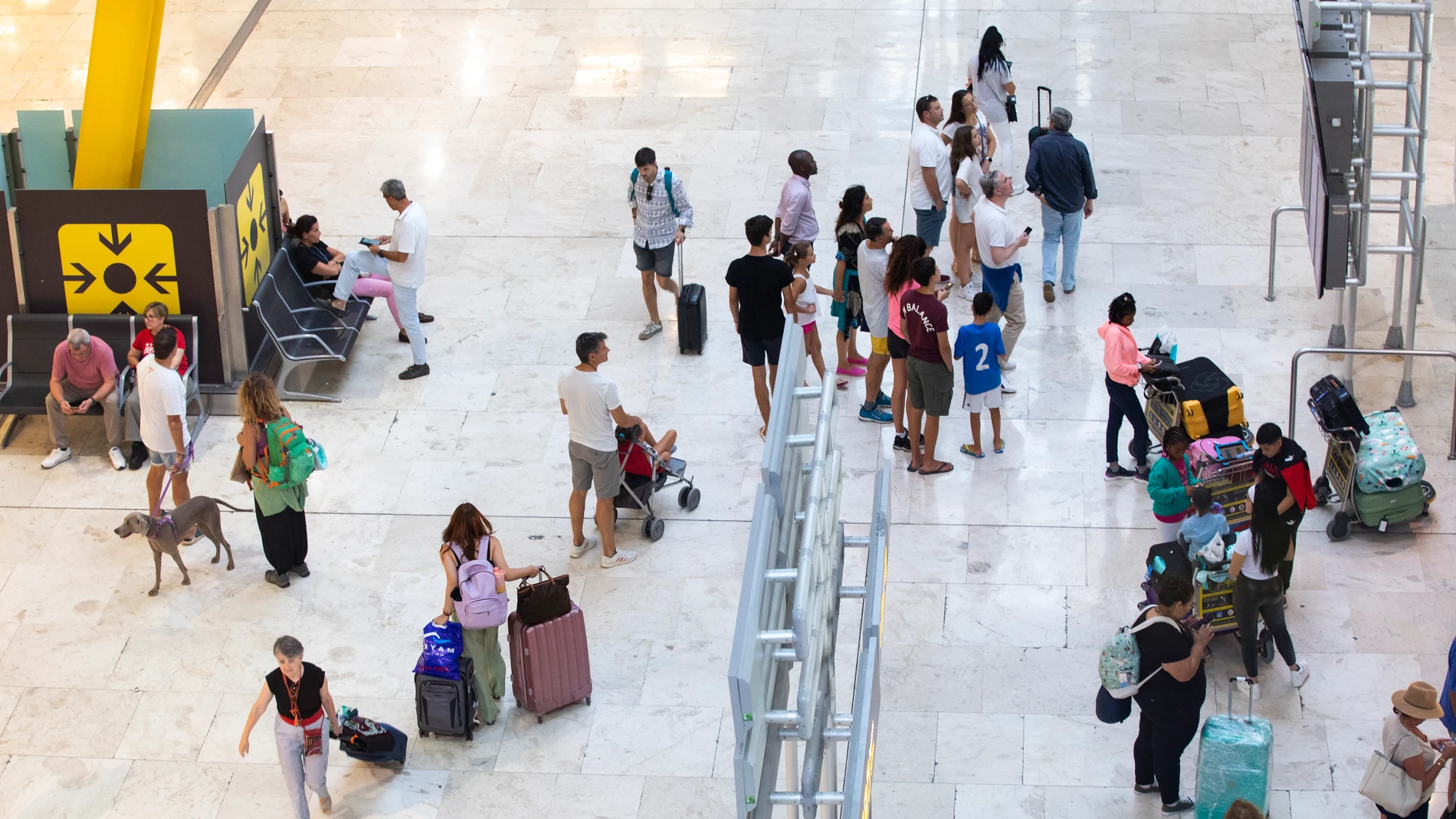  Viajeros y turistas con maletas en la terminal T4 del aeropuerto Adolfo Suarez Madrid Barajas. © Jesús G. Feria.