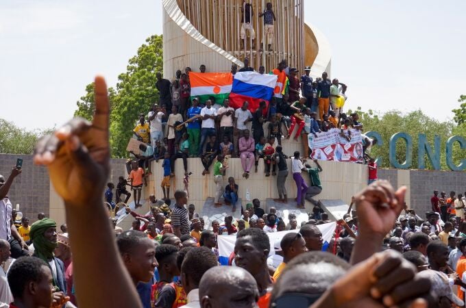 People display a Russia and a Niger flags outside the National Assembly building during a protest in Niamey, Niger, 30 July 2023. 