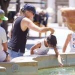 Un niño se refresca este martes en una fuente en Murcia. Las temperaturas se prevé que subirán aún más mañana miércoles en el día álgido de la ola de calor con termómetros que llegarán a 44 grados