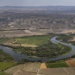 Cultivos de regadío intensivo en torno a un meandro del río Ebro a su paso por Osera de Ebro, en Zaragoza. Al fondo, el desierto de los Monegros.
