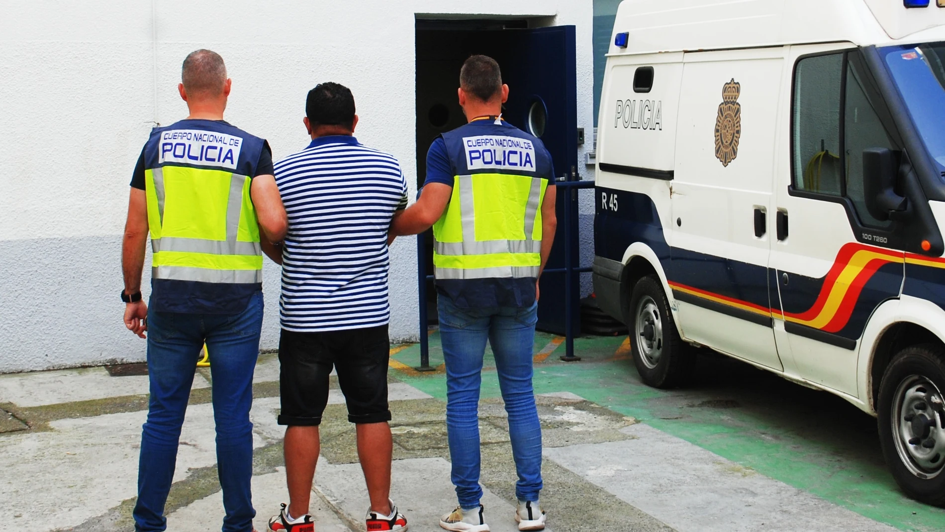 Dos agentes trasladan al hombre de 44 años detenido en Loiu (Vizcaya) condenado en El Salvador a 5 años por pertenencia a organización criminal