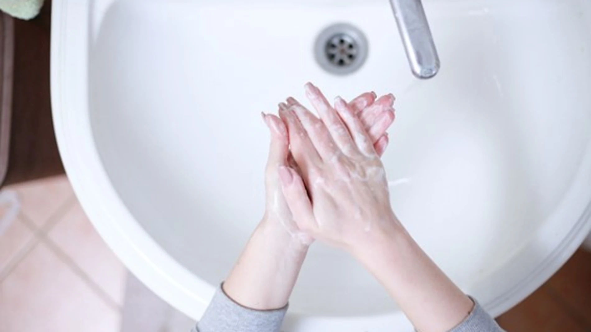 Mujer lavándose las manos con jabón 