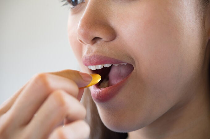 Mujer toma una píldora de omega-3