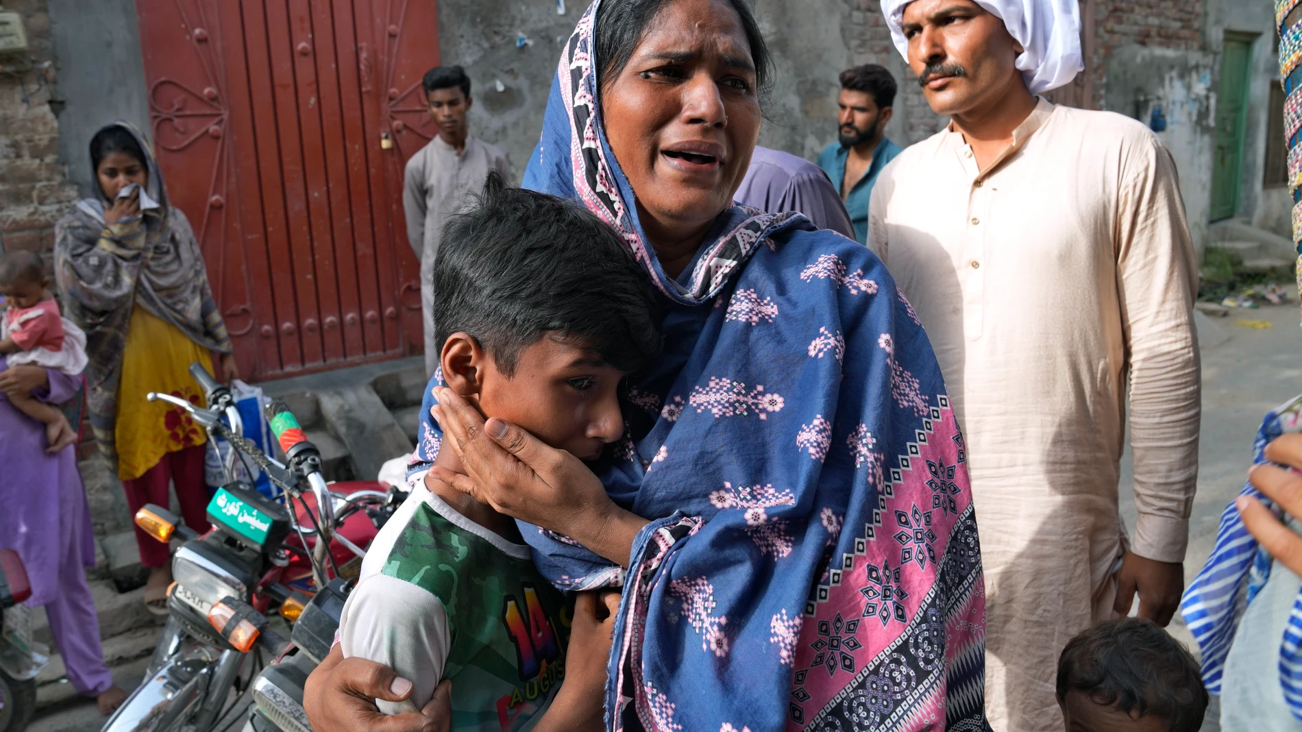 A Christian woman and a boy weep after seeing their homes vandalized by angry Muslim mob in Jaranwala near Faisalabad, Pakistan, Thursday, Aug. 17, 2023. Muslims in eastern Pakistan went on a rampage Wednesday over allegations that a Christian man had desecrated the Quran, demolishing the man's house, burning churches and damaging several other homes, police and local Christians said. (AP Photo/K.M. Chaudary)