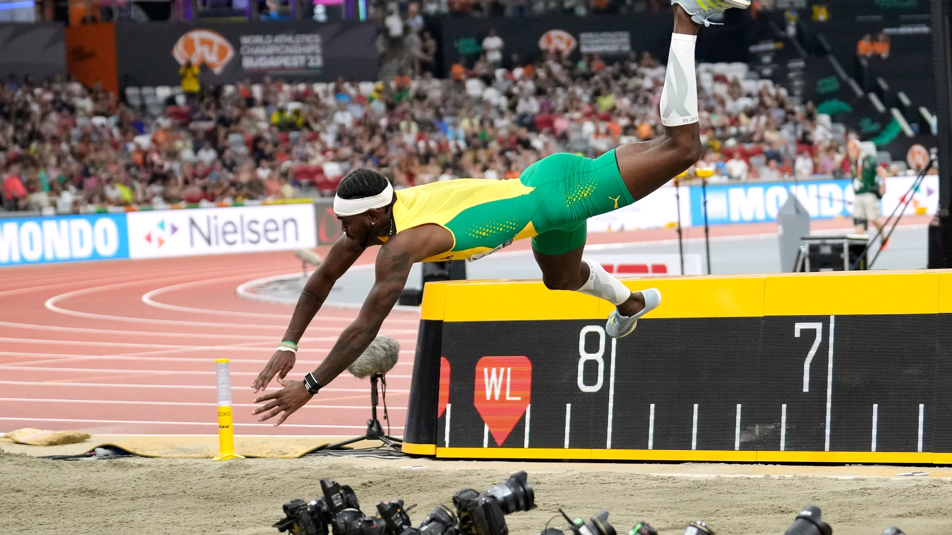 Carey Mcleod, of Jamaica, loses control as he competes in the men's long jump final during the World Athletics Championships in Budapest, Hungary, Thursday, Aug. 24, 2023. (AP Photo/Ashley Landis)