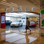 A man walks next to a Tesla showroom in Beijing, China.