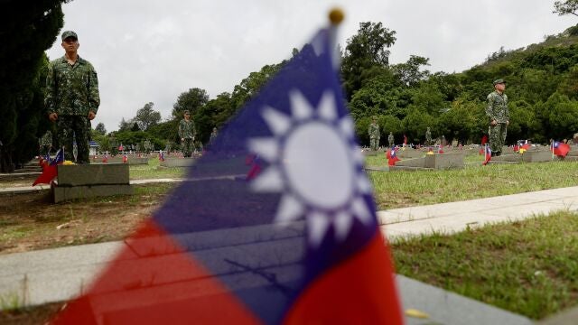  Taiwanese soldiers stand next to the tombstones of the fallen soldiers during the 65th Anniversary of the artillery battle between Taiwan and China, in Kinmen, Taiwan.