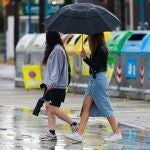 Dos chicas caminan por la calle bajo un paraguas el pasado domingo en Ibiza durante el temporal de lluvias y tormentas con vientos de hasta 120 kilómetros por hora