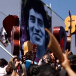 Fellow musicians raise their guitars as a tribute to Chile's folk singer Victor Jara during his burial at the General Cemetery in Santiago, Saturday, Dec. 5, 2009.
