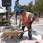 Un trabajador de la construcción junto a un termómetro que marca cuarenta grados este martes en la avenida de la Fama de Murcia. 