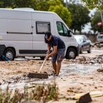 Una persona trata de evitar que el agua se acumule en una de las zonas afectadas por las inundaciones provocadas por la DANA este lunes en El Álamo, Madrid (España)
