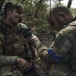 A soldier of Ukraine's 3rd Separate Assault Brigade gives first aid to his wounded comrade, call sign Polumya (Flame), 19, near Bakhmut, the site of fierce battles with the Russian forces in the Donetsk region, Ukraine, Monday, Sept. 4, 2023. 