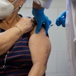 Un sanitario vacuna a una mujer mayor