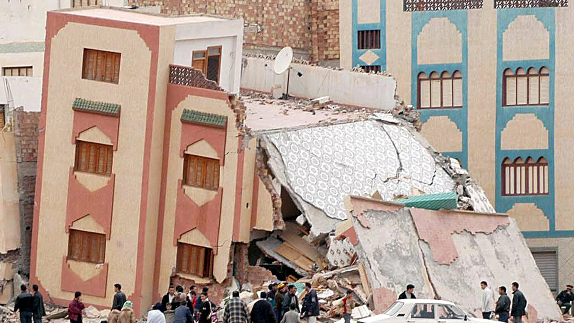 Vecinos de la localidad marroquí de Izemuren junto a uno de los edificios derrumbado a causa de un seismo. Un fuerte terremoto de 6,3 grados en la escala abierta de Richter sacudió el 24 de febrero de 2004 el norte de Marruecos y causó la muerte de al menos 229 personas en las aldeas próximas a la ciudad de Alhucemas.