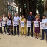 Los diputados de Compromís muestran un cartel con la cara del conseller de Educación, José Antonio Rovira