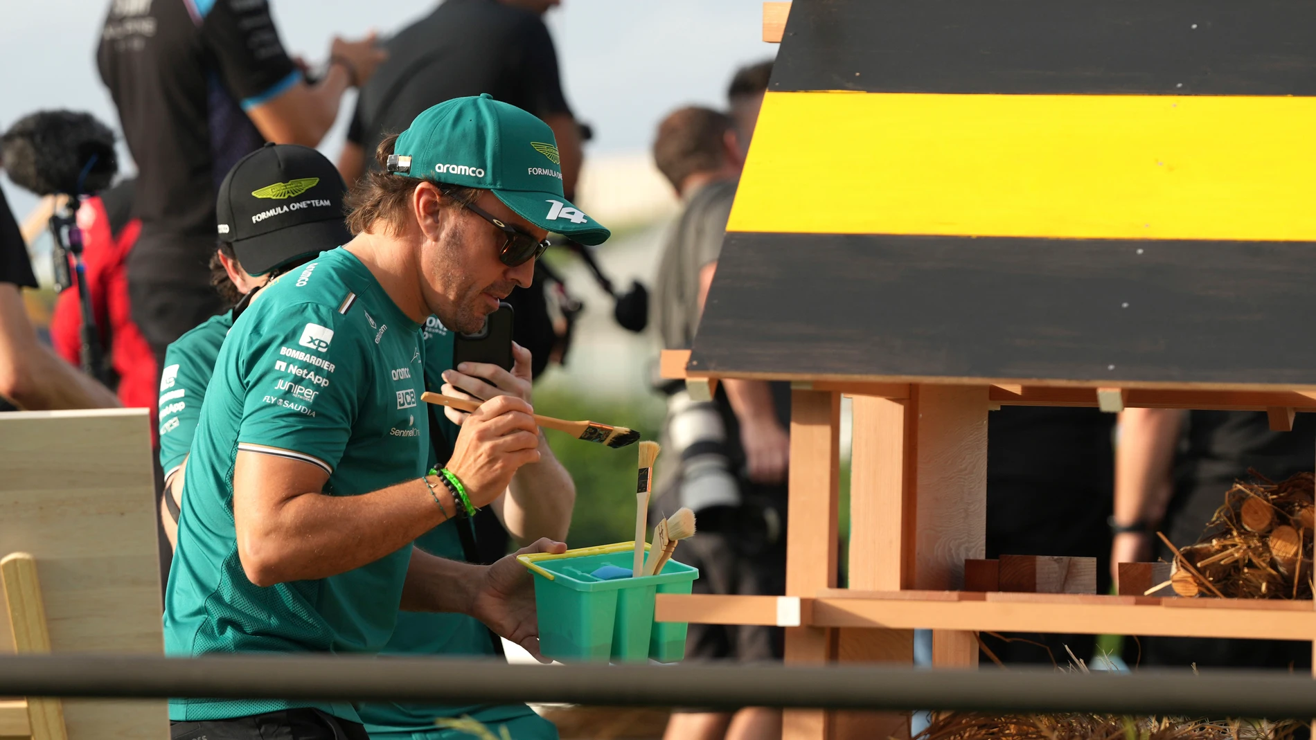 Aston Martin driver Fernando Alonso of Spain paints an insect house where bees and others insect will be able to seek refuge, during former Formula 1 world champion Sebastian Vettel's Buzzin' Corner project that aims to raise awareness for biodiversity, ahead of the Japanese Formula One Grand Prix at the turn two of the Suzuka Circuit in Suzuka, central Japan, Thursday, Sept. 21, 2023. (AP Photo/Toru Hanai)