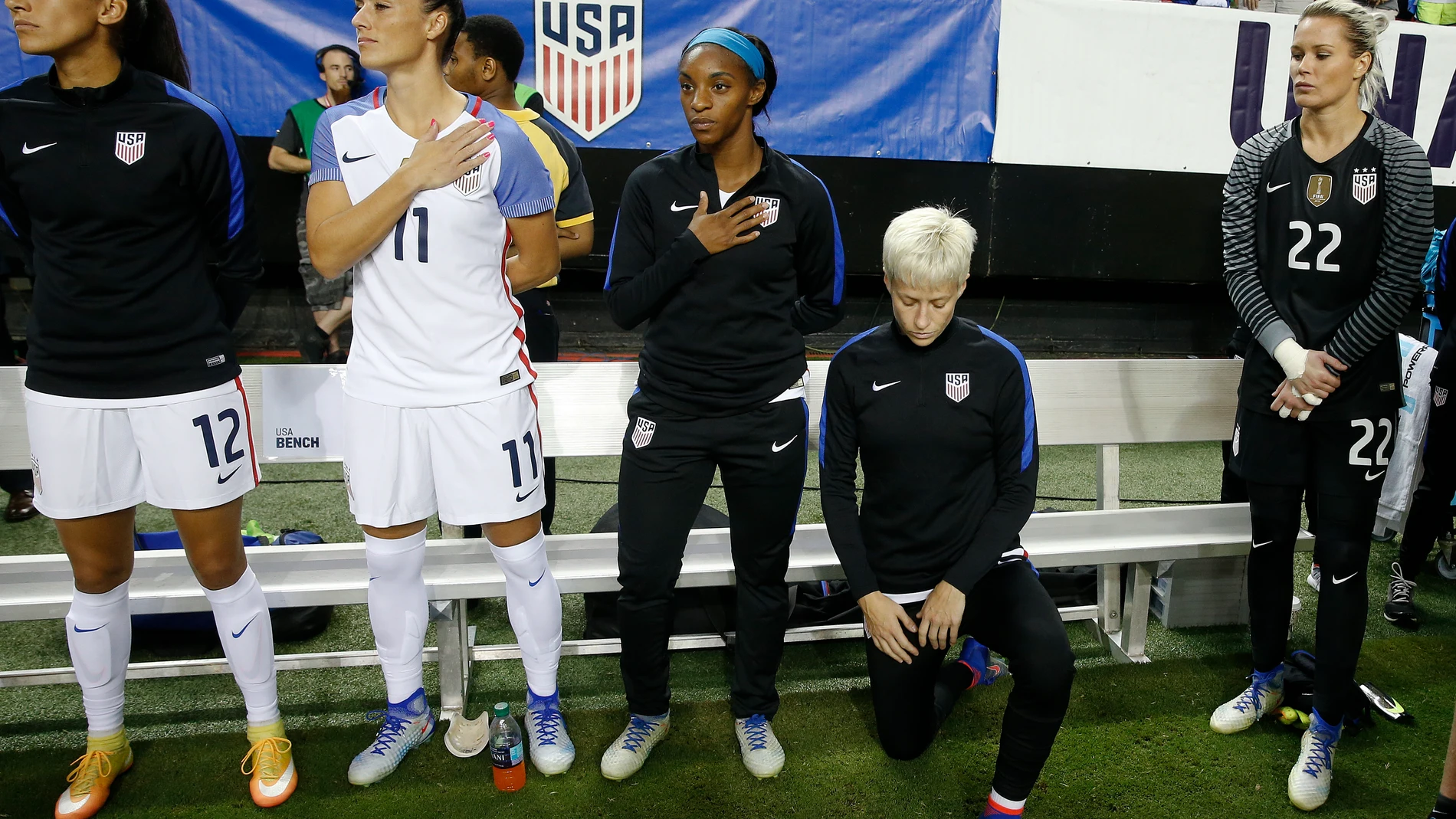FILE - USA's Megan Rapinoe kneels next to teammates Christen Press (12), Ali Krieger (11), Crystal Dunn (16) and Ashlyn Harris (22) as the U.S. national anthem is played before an exhibition soccer match against Netherlands Sunday, Sept. 18, 2016, in Atlanta. Rapinoe knelt during the national anthem in solidarity with Colin Kaepernick, the former San Francisco 49ers quarterback who knelt during the anthem to call attention to racial inequality.(AP Photo/John Bazemore, File)