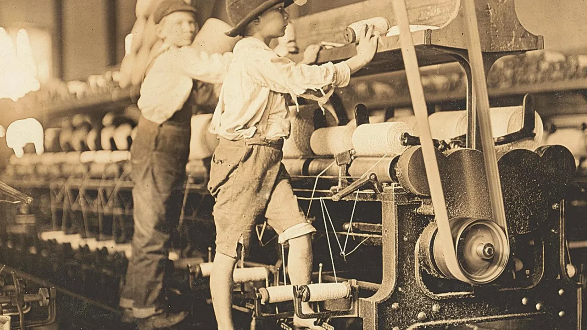 Unos niños trabajando en una fábrica de telares mecánicos donde se les empleaba por su bajo coste