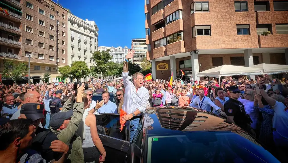 El líder del PP, Alberto Núñez Feijóo antes de abandonar el acto por la igualdad saludó a los asistentes desde el coche.