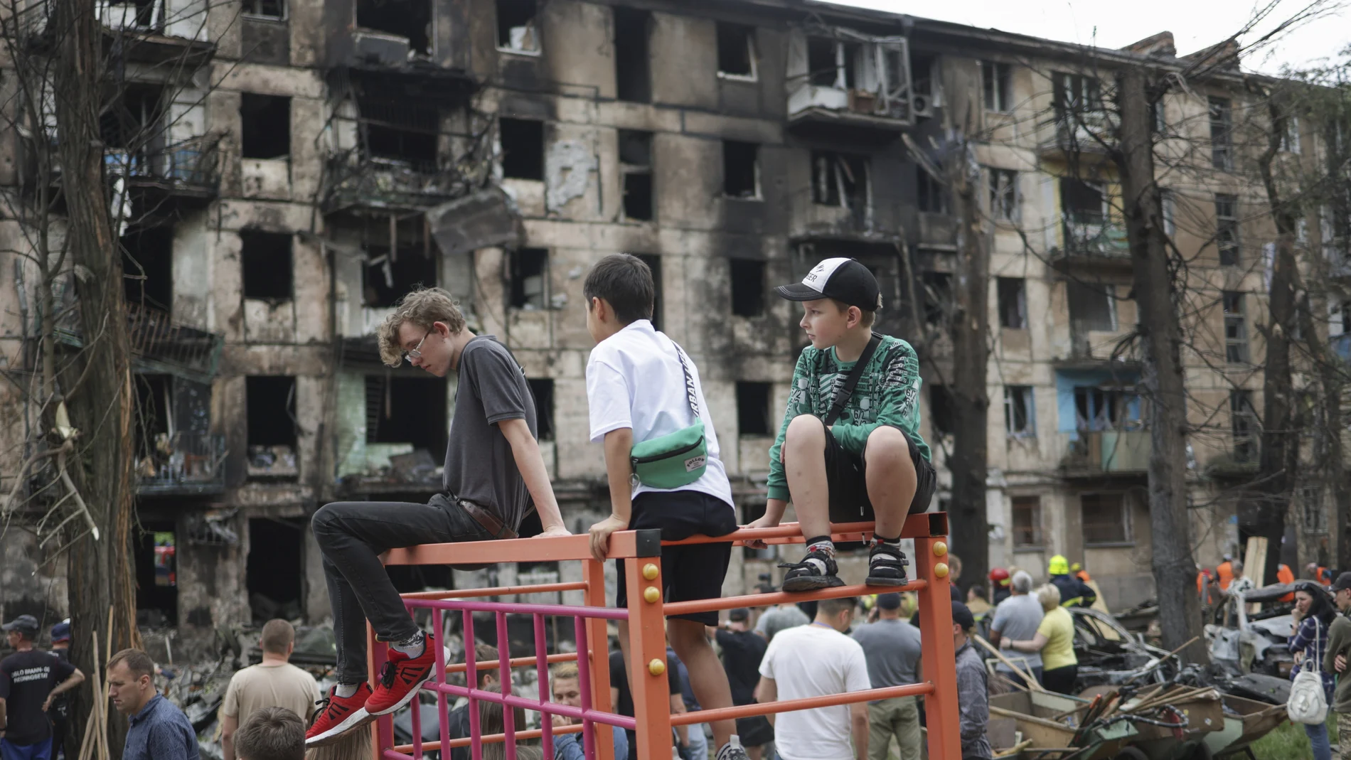 Children look at the scene of the latest Russian rocket attack that damaged a multi-storey apartment building in Kryvyi Rih, Ukraine