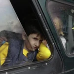 Un niño armenio desplazado mira por la ventana de un coche
