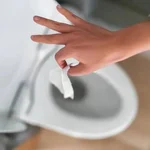 Una toallita siendo arrojada al inodoro