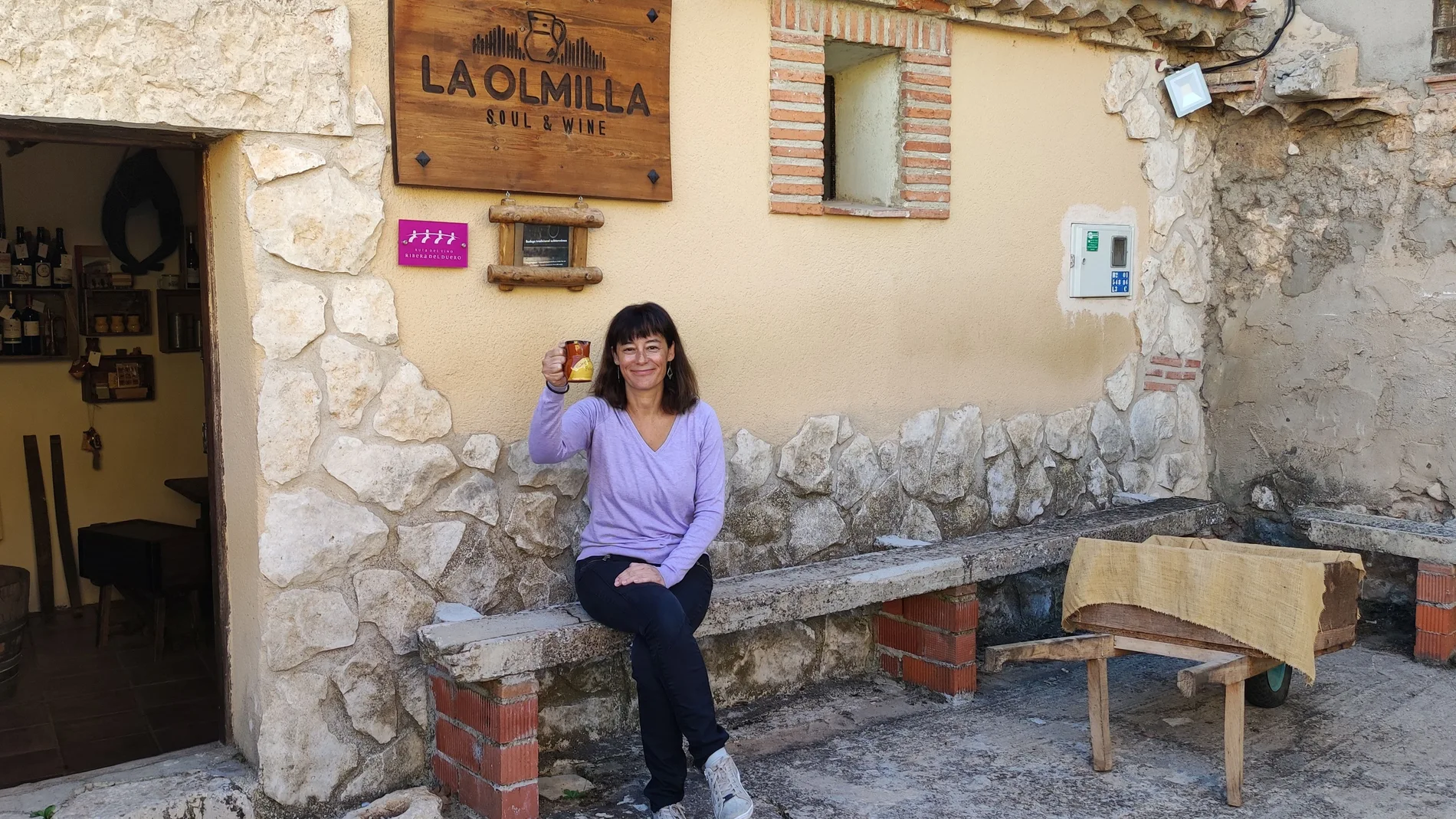Silvia Camacho, a la entrada de la bodega con un tradicional jarrillo de vino