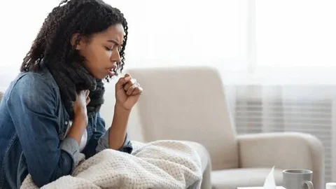 Una joven tose a causa de una bronquitis