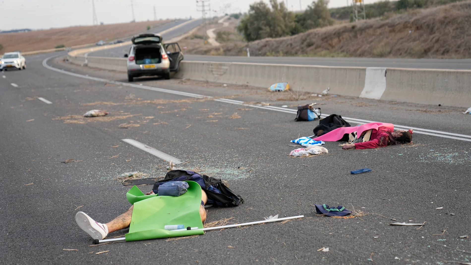 FILE - Palestinian gunmen lie on the road near Sderot, Israel, on Saturday, Oct. 7, 2023. Palestinian militants from the Gaza Strip infiltrated southern Israel Saturday and fired thousands of rockets into the country, prompting Israel to begin striking targets in Gaza in response. (AP Photo/Ohad Zwigenberg, File)