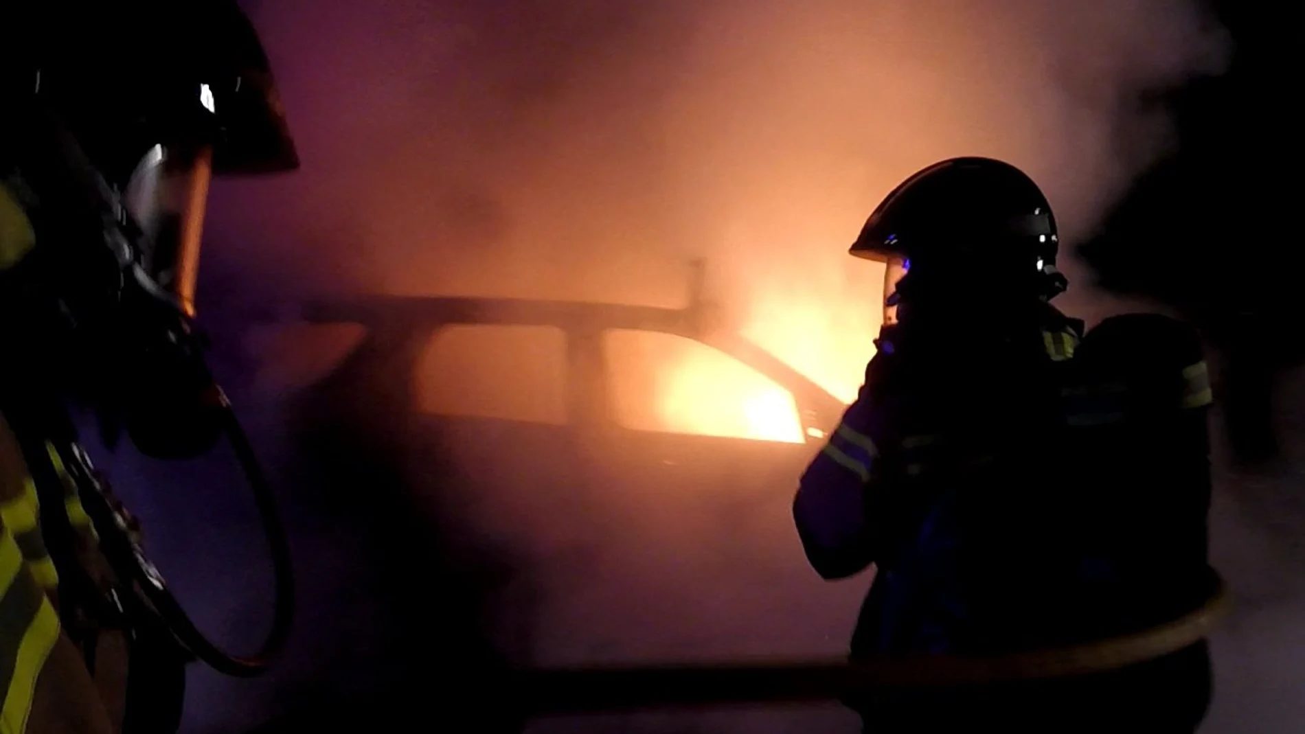 Varios bomberos apagan el todoterreno Land Rover incendiado, utilizado el lunes en el intento de fuga de un preso, tras recibir el aviso a las 00:20 de la noche entre el lunes y el martes