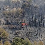 Un camión de bomberos trabaja en la zona del incendio forestal originado en la localidad madrileña de Collado Mediano.