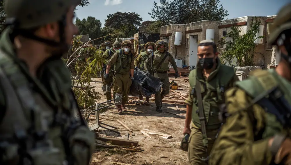 Las fuerzas israelíes extraen los cadáveres de residentes israelíes de una casa destruida mientras continúan los combates entre las tropas israelíes y los militantes islamistas de Hamas.