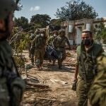 Las fuerzas israelíes extraen los cadáveres de residentes israelíes de una casa destruida mientras continúan los combates entre las tropas israelíes y los militantes islamistas de Hamas.