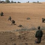 Israeli soldiers take position next to Kfar Aza kibbutz near the border with Gaza, 10 October 2023.