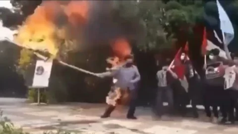 Un hombre se prende fuego mientras quema una bandera de Israel