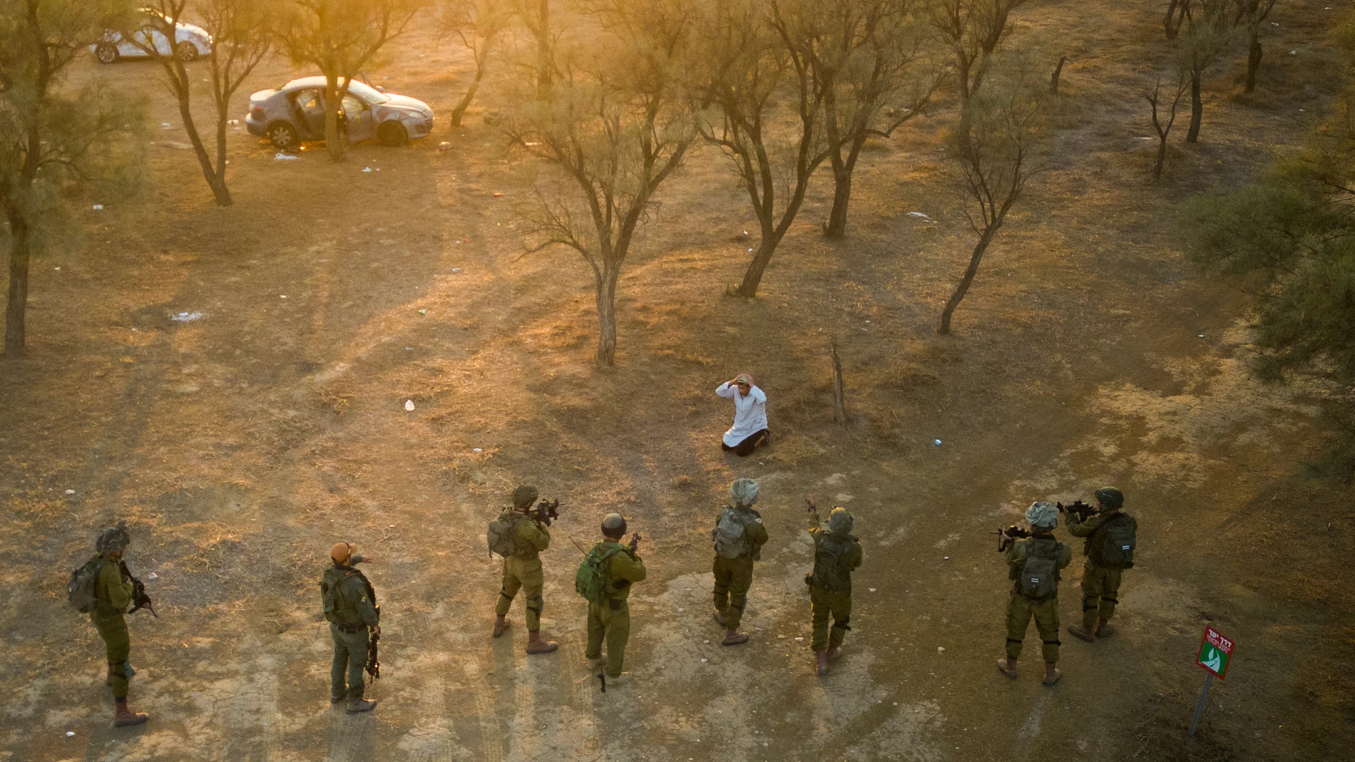 Israeli soldiers surround a Palestinian who ran at them with a knife at the site of a music festival near the border with the Gaza Strip Thursday, Oct. 12, 2023. At least 260 Israeli festivalgoers were killed during the attack last Saturday. (AP Photo/Erik Marmor)