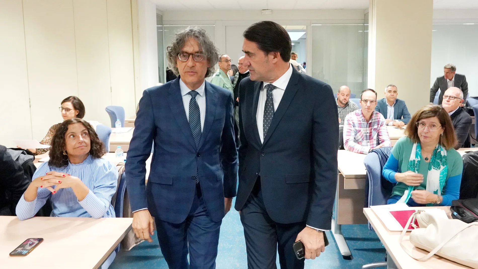 El consejero Suárez-Quiñones conversa con el fiscal superior de Castilla y León, Santiago Mena, antes de la jornada