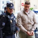 El acusado, JC.G.D, es conducido por un Policía a declarar en la primera jornada del juicio en la Audiencia Provincial de León