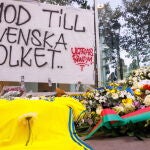 Una camiseta de la selección sueca de fútbol y flores se colocan junto a una pancarta en la que se lee "Coraje al pueblo sueco" durante una conmemoración por los dos aficionados suecos al fútbol que fueron asesinados