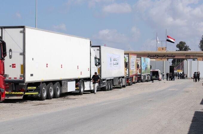 Camiones de un convoy de ayuda humanitaria estacionados frente a la puerta fronteriza entre Egipto y Gaza, en Rafah