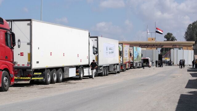 Camiones de un convoy de ayuda humanitaria estacionados frente a la puerta fronteriza entre Egipto y Gaza, en Rafah