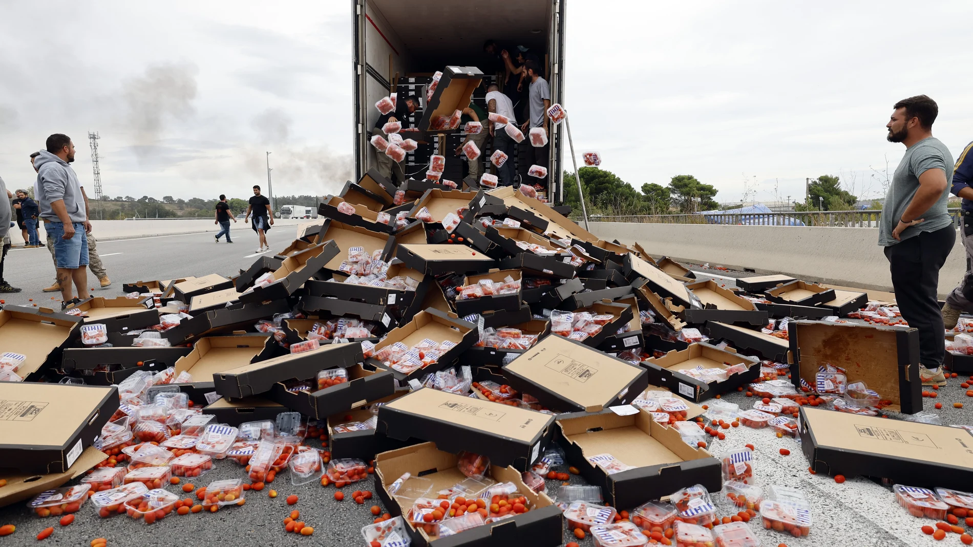 Le Boulou (France), 19/10/2023.- French winemakers destroy a shipment of tomatoes coming from Spain during a demonstration by the tollbooth in Le Boulou, near the Spanish border, south of France, 19 October 2023. Winegrowers and winemakers from south of France are protesting against the introduction of Spanish wines. (Protestas, Francia, España) EFE/EPA/GUILLAUME HORCAJUELO