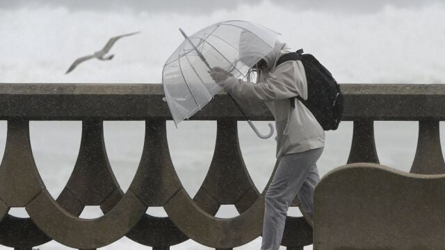 Una persona se protege de la lluvia y el viento con un paraguas, en A Coruña, Galicia. Imagen de archivo