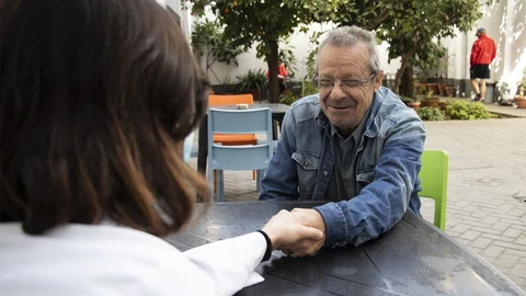 Un voluntario de Cáritas atiende a una persona sin hogar