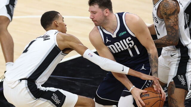 Wembanyama intenta arrebatar el balón a Luka Doncic